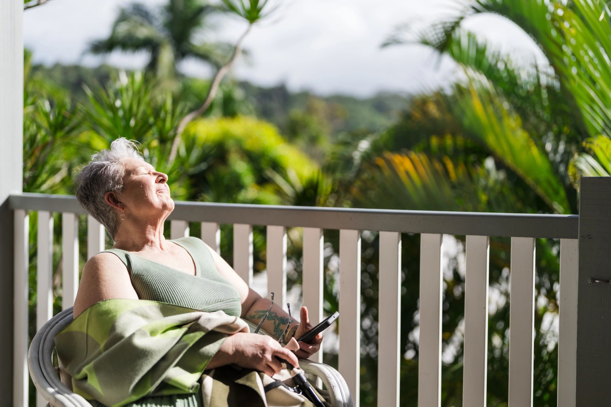 Senior holiday guest relaxing in the sunshine